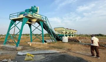 A heavy-duty Nilkanth NE-60-SP stationary concrete batching plant featuring a 100-ton cement silo, installed for major infrastructure work in Dwarka, Gujarat.