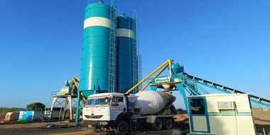 A massive dual concrete batching plant installation featuring Nilkanth NE-60-SP pan mixer and NE-60-STS twin-shaft models, operating continuously in Mandvi.